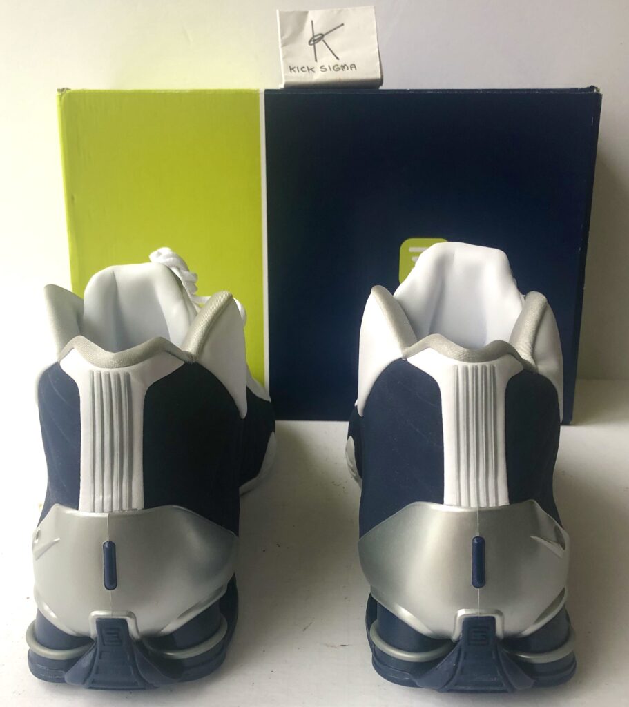 The Nike Shox BB4, white, navy "Olympic" colorway, rear view. 