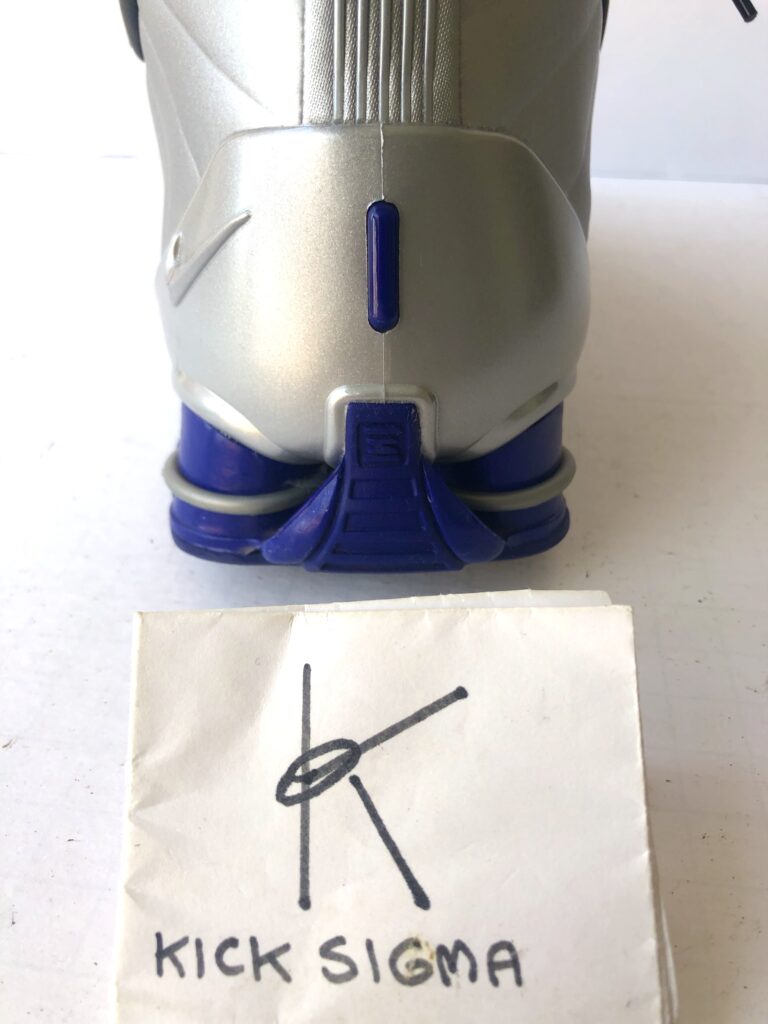 The Nike Shox BB4, black, silver, lapis colorway, rear view. 